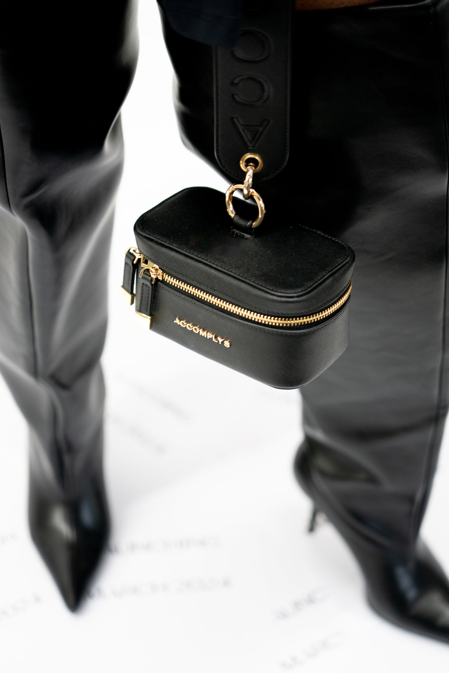 BLACK DROP wristlet with gold lettering.