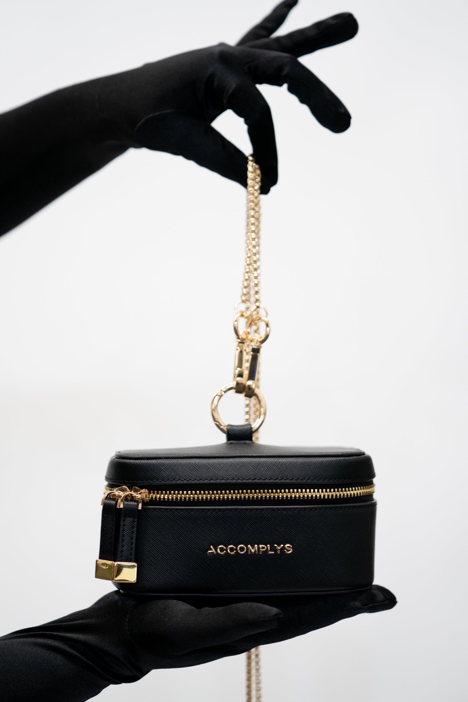 BLACK DROP wristlet with gold crossbody chain.