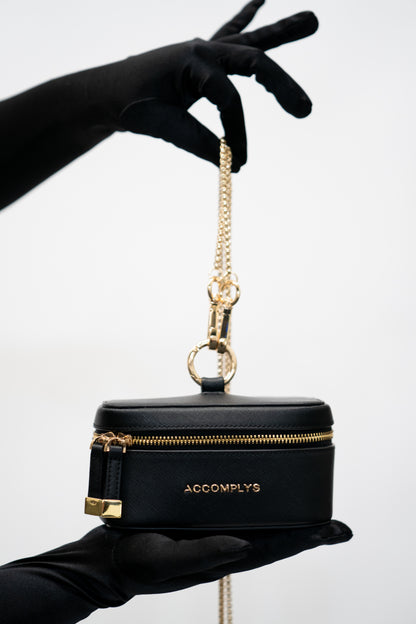 BLACK DROP wristlet with gold crossbody chain.